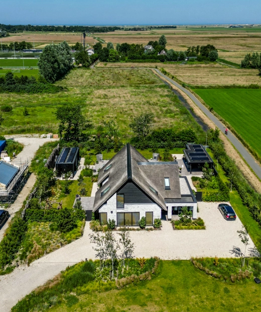 Bovenaanzicht van boerderijwoning met een groot kavel daaromheen
