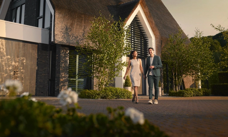 Echtpaar wandelt voor maatkwerk villa met rieten kap