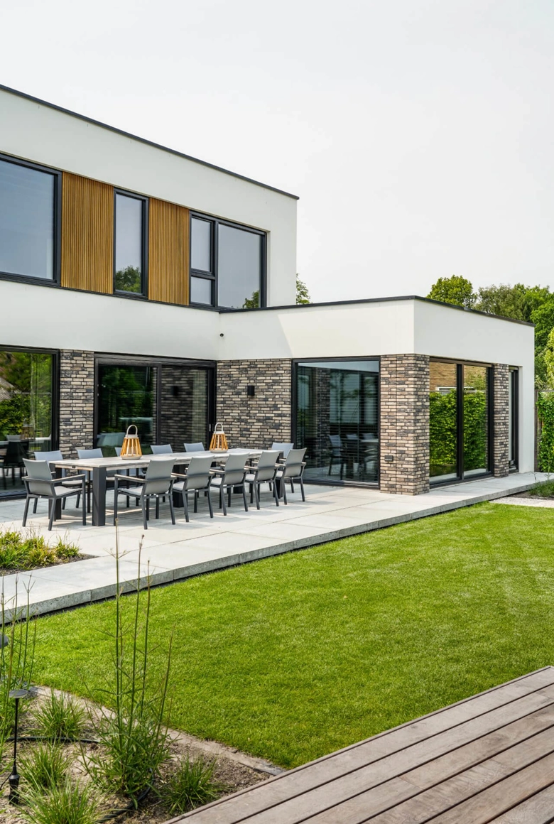 Zijaanzicht van kubistische woning met wit houten gevelbekleding