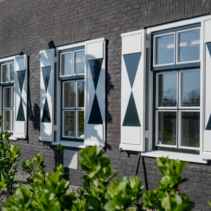 landelijke-boerderijwoning-zijaanzicht-donkere-gevel-luiken.jpg