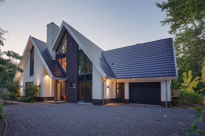 Voorgevel van een moderne villa met garage en grote raampartijen