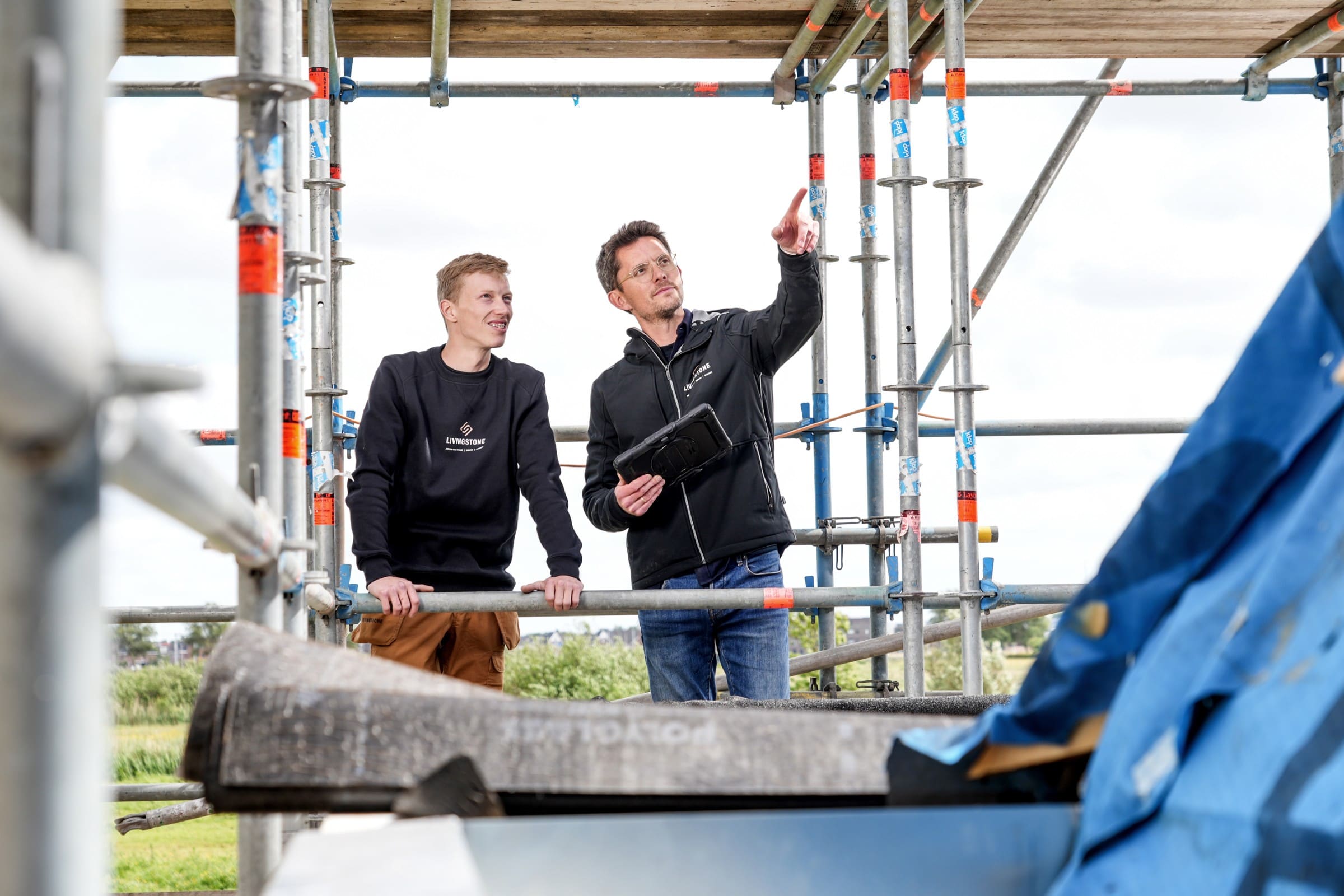Uitvoerder en projectleider overleggen samen op de bouwplaats