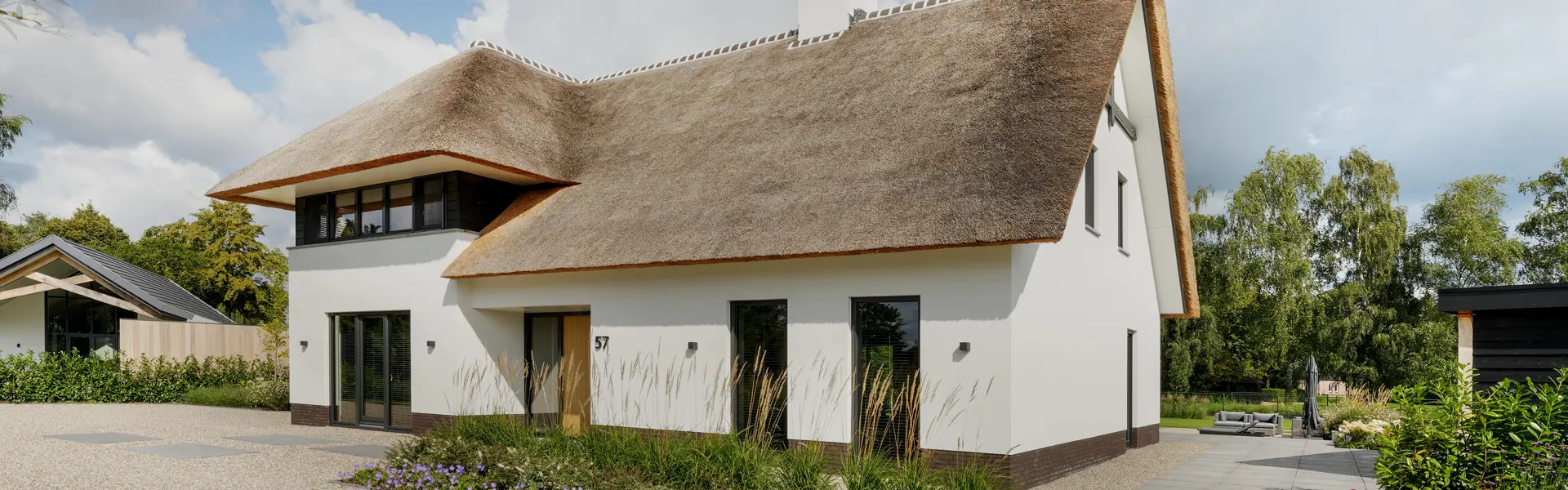 Landelijke villa met rieten kap met witte gevelbekleding