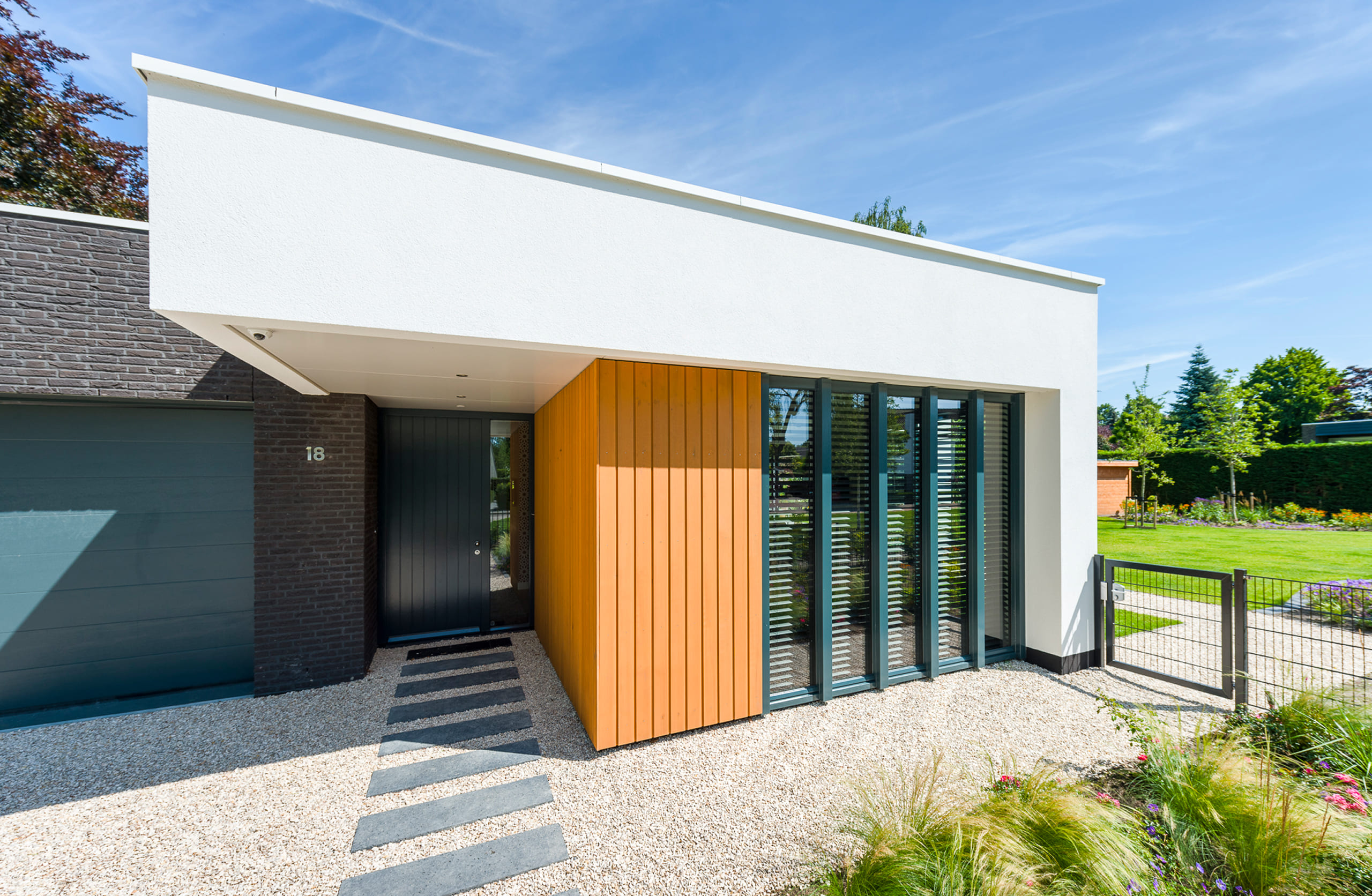 De voorzijde van een bungalow met witte gevel