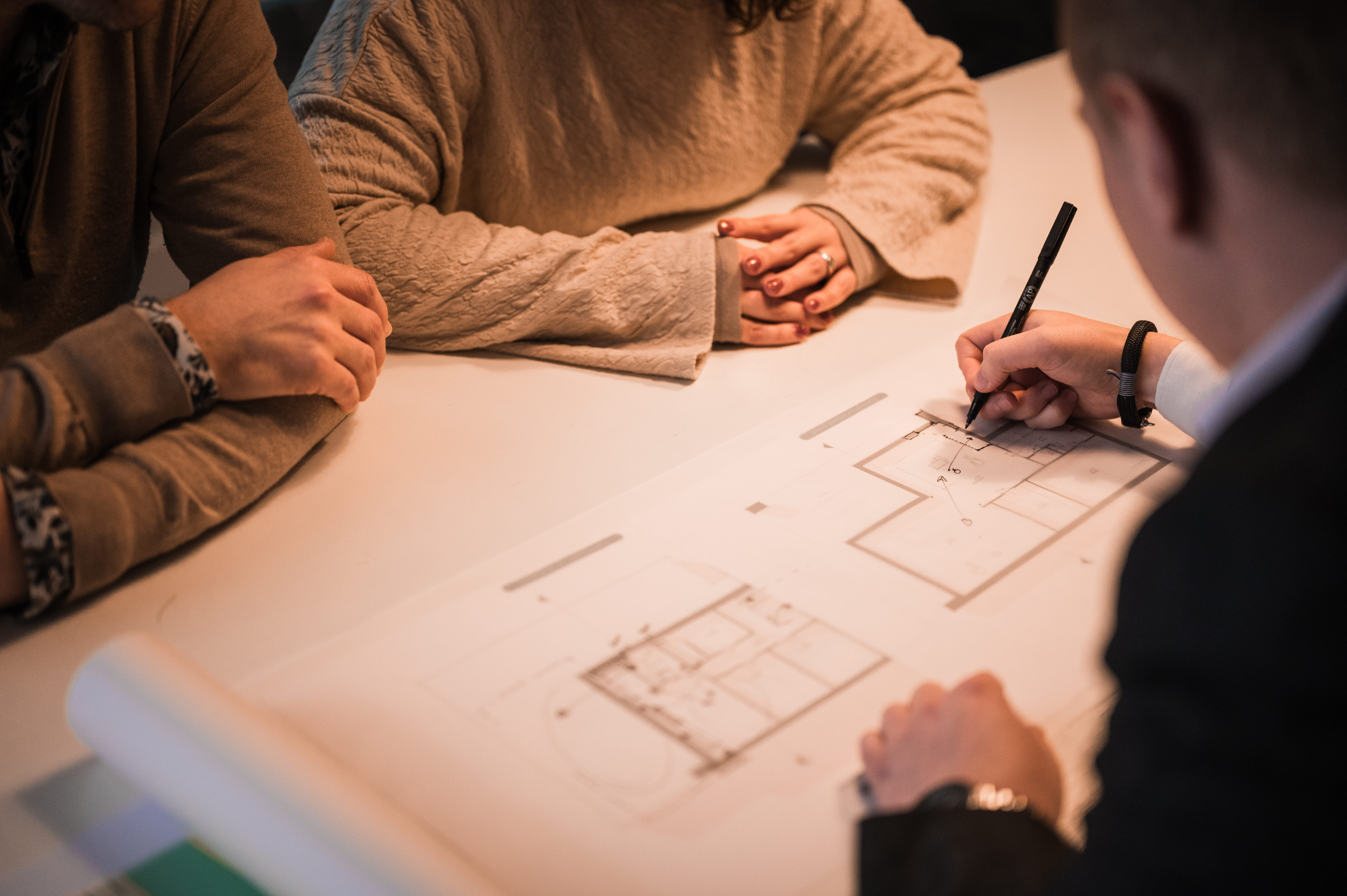 Architect schets een ontwerp en is in gesprek met klanten 