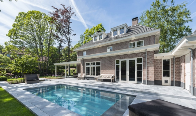 Een luxe buitenzwembad gelegen in de achtertuin van een klassieke notariswoning