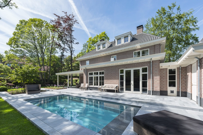 Een luxe buitenzwembad gelegen in de achtertuin van een klassieke notariswoning