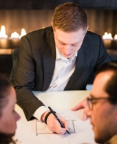 Architect schets een ontwerp en is in gesprek met klanten