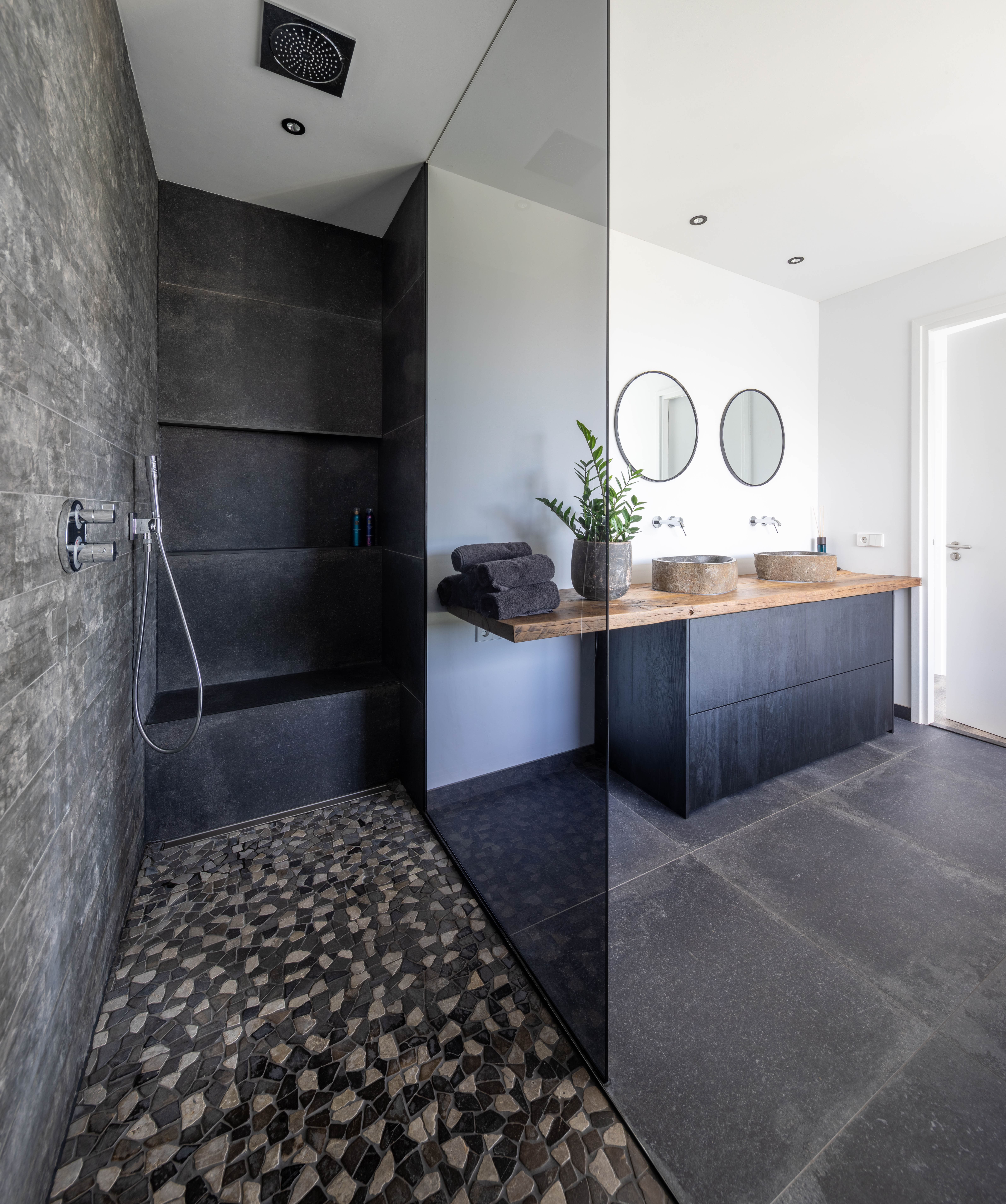 Badkamer met donkere wand- en vloerbetegeling