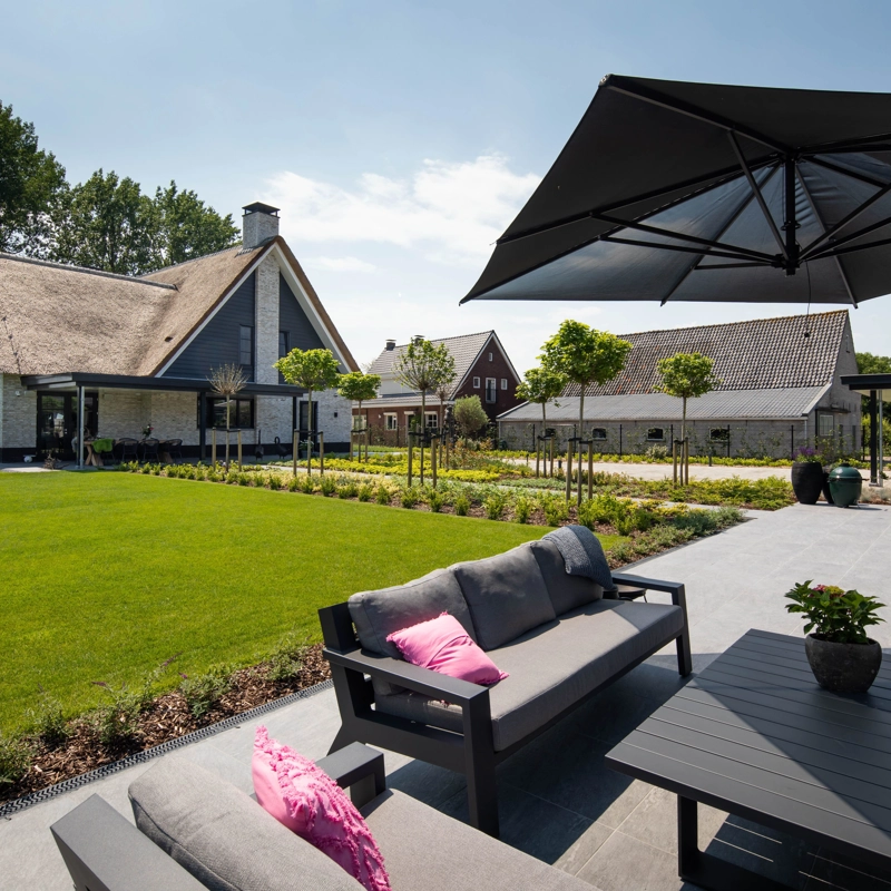 Het terras in de achtertuin van een landelijke villa met rieten kap