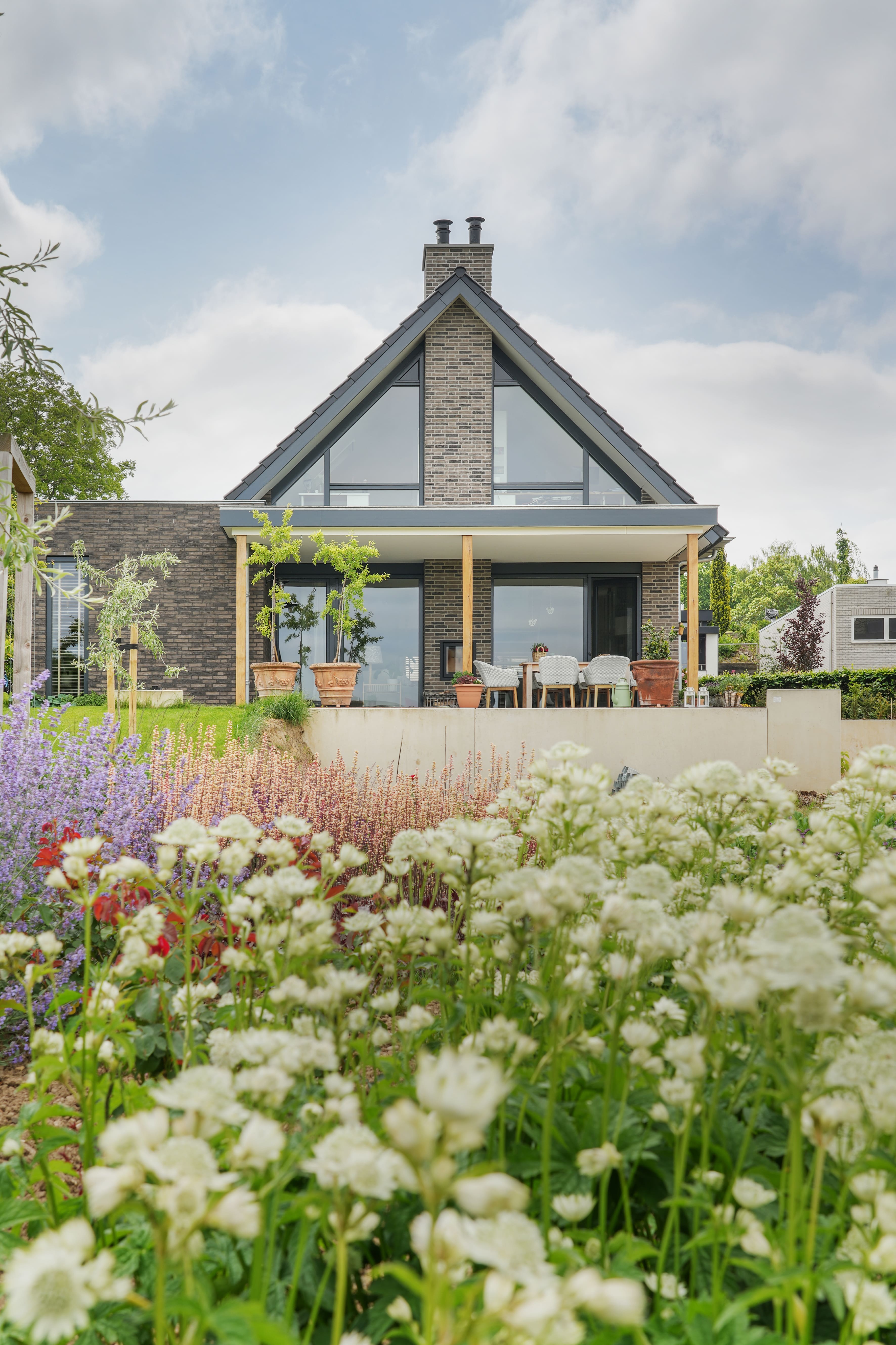 Achterzijde schuurwoning met weelderige bloementuin