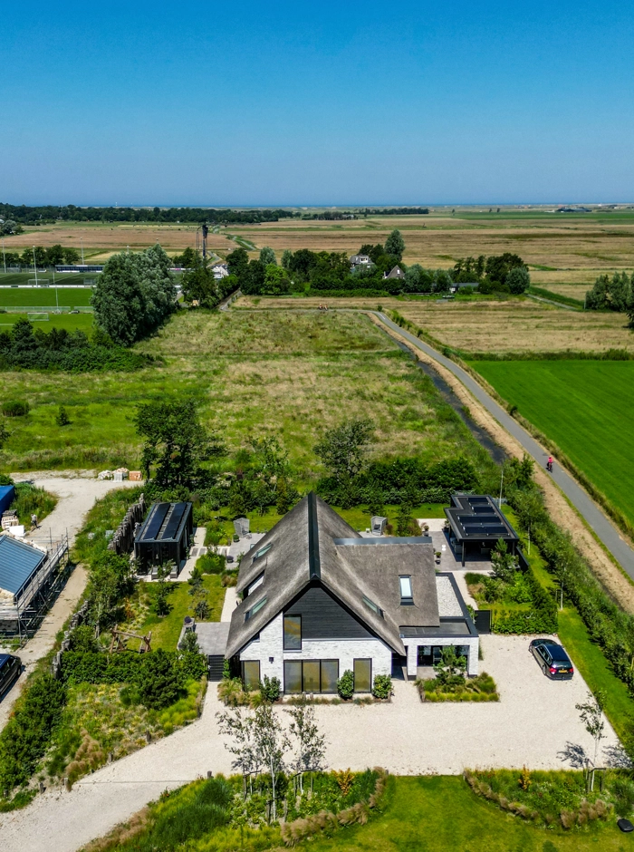Dronefoto van boerderijwoning met groot perceel