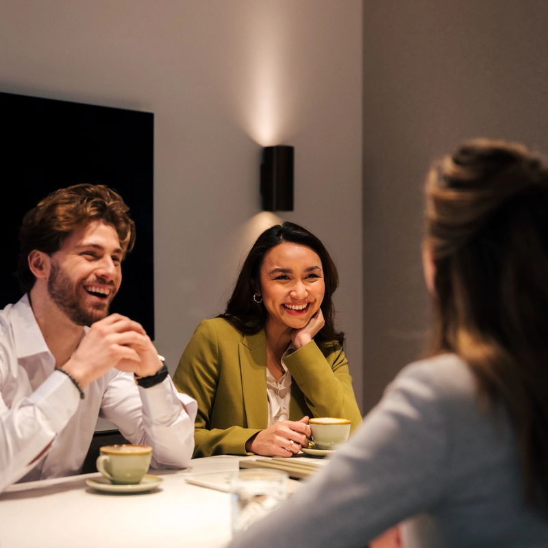 Interieurarchitect zit met klanten aan tafel voor een adviesgesprek