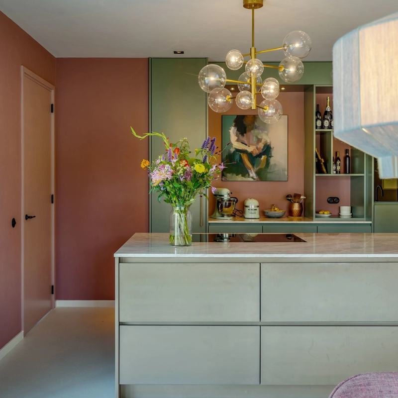 Vooraanzicht van een mintgroene keuken en roze wandbekleding