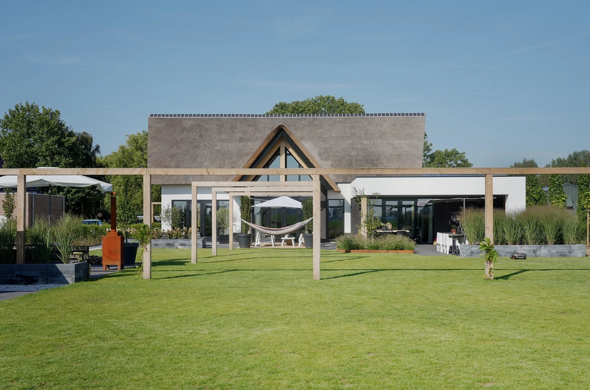 Achterzijde van een landelijke villa met luxe design tuinbeleving