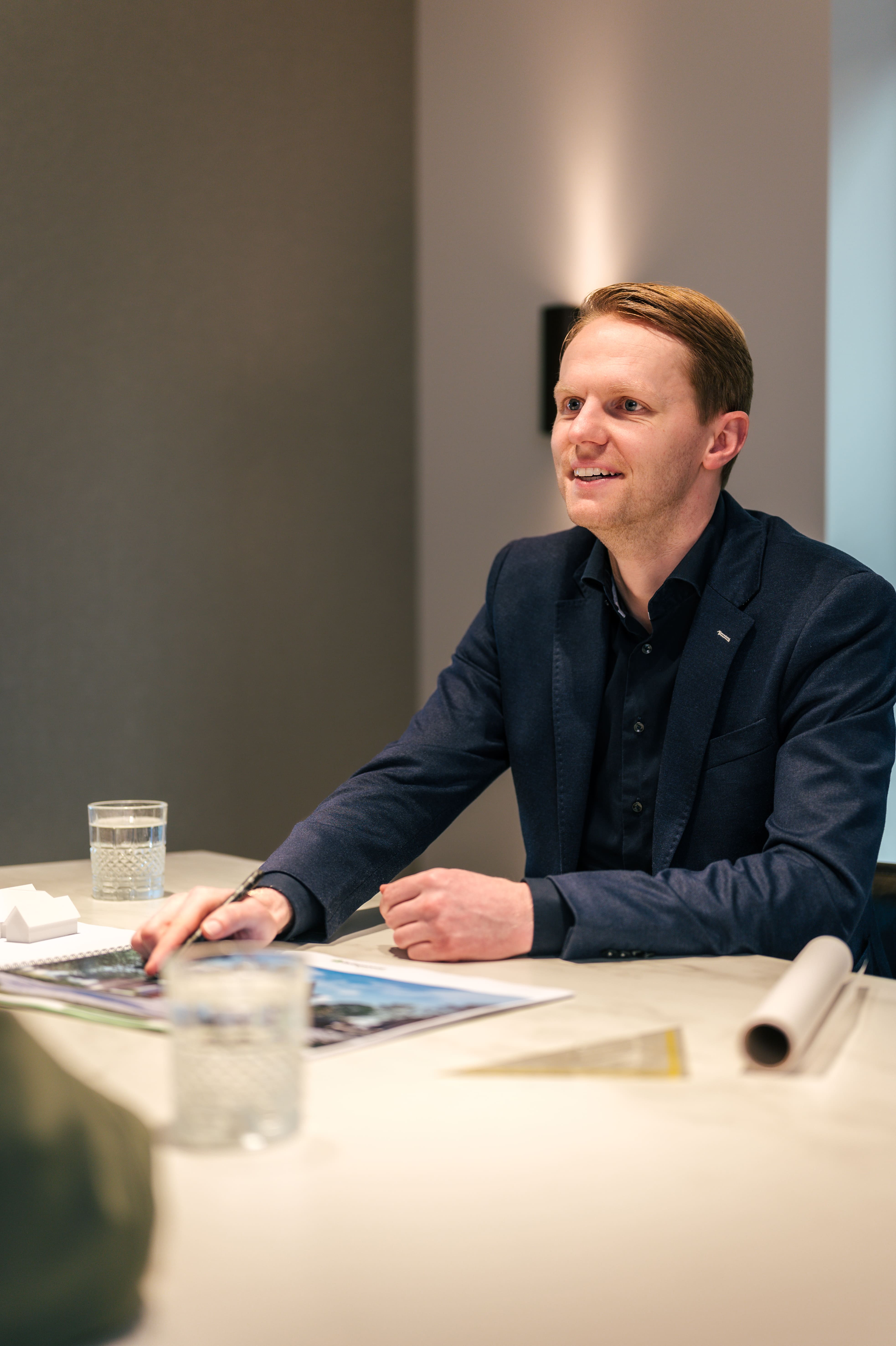 Vriendelijke architect zit aan tafel met klant