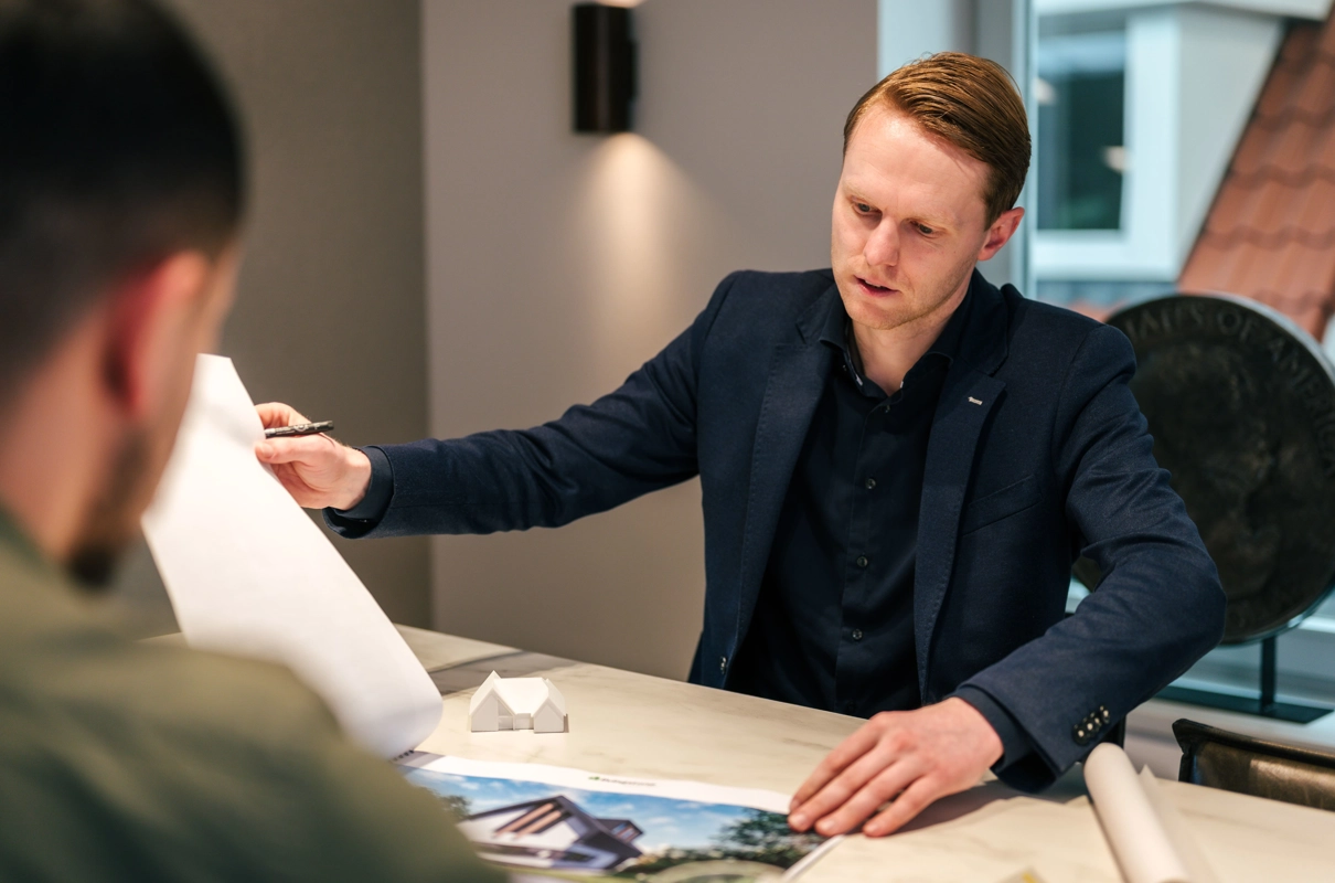 Architect bladert tijdens een adviesgesprek in documenten