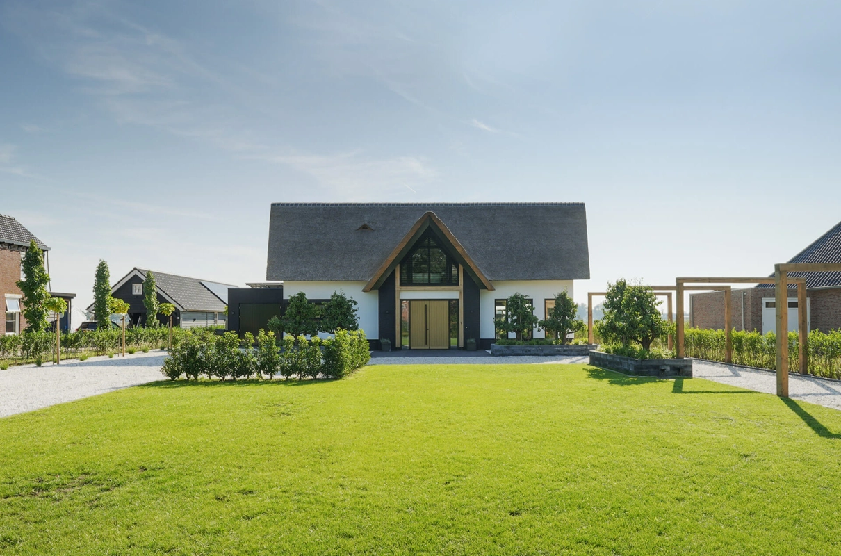Voorzijde van een landelijke villa met rieten kap en houten spanten