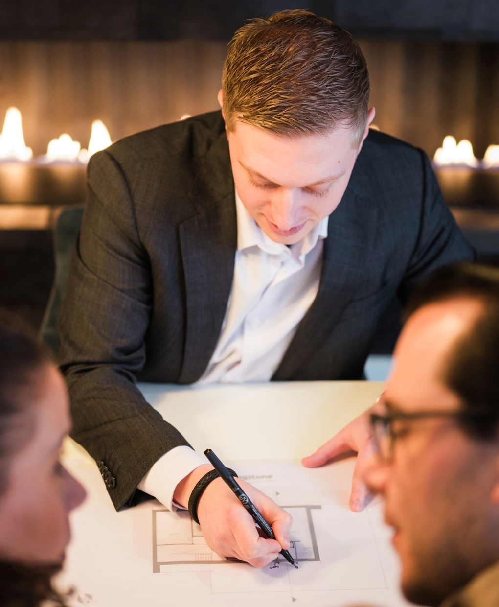 Architect schets een ontwerp en is in gesprek met klanten