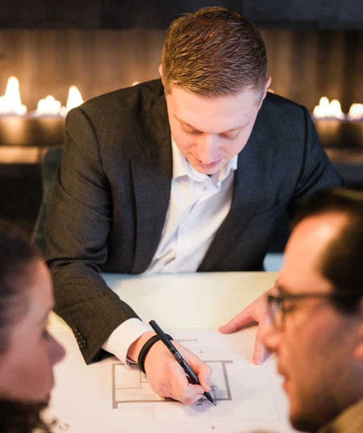 Architect schets een ontwerp en is in gesprek met klanten