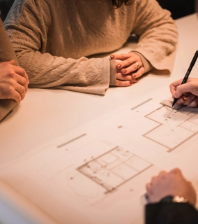 Architect schets een ontwerp en is in gesprek met klanten