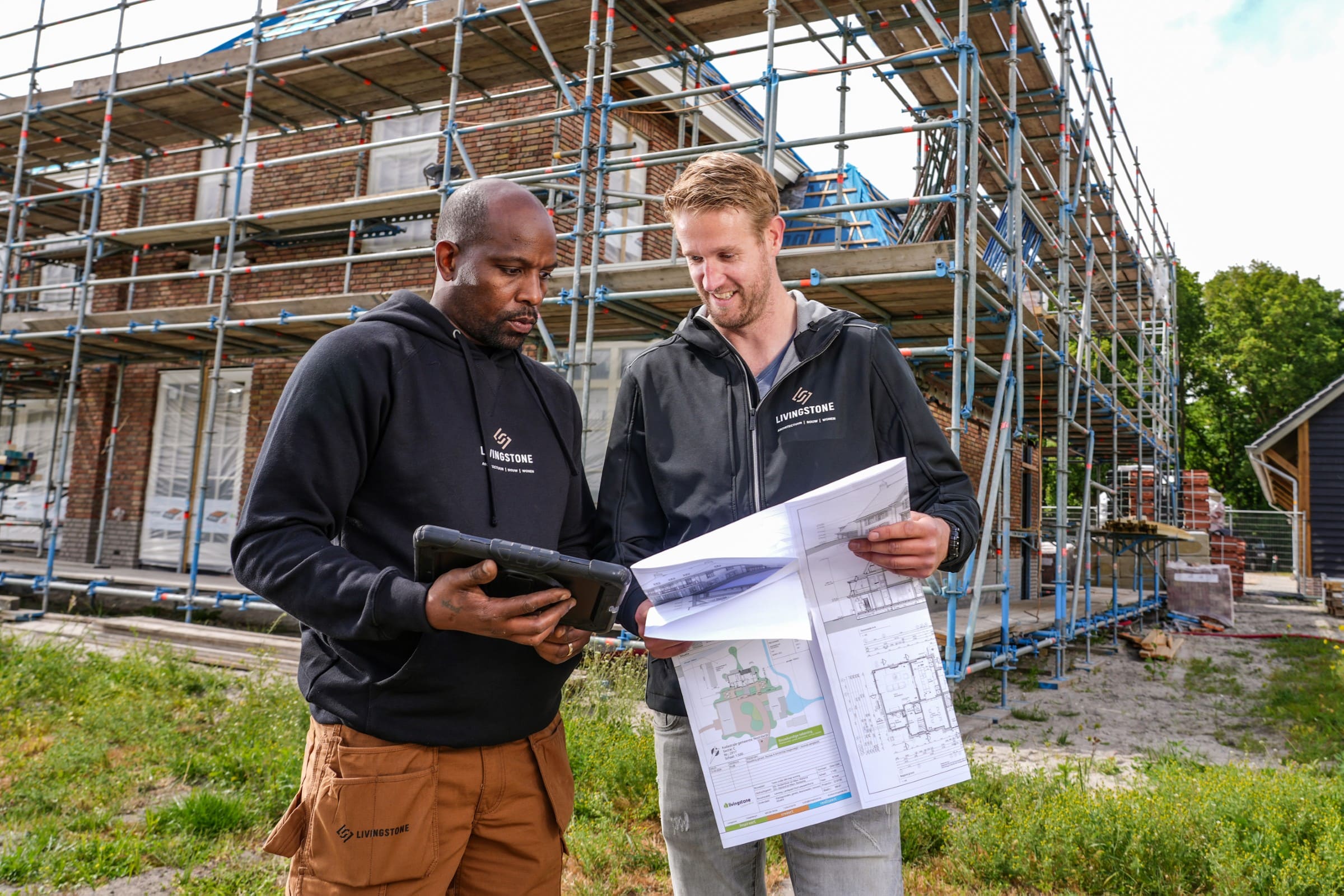 Uitvoerder en projectleider overleggen samen op de bouwplaats
