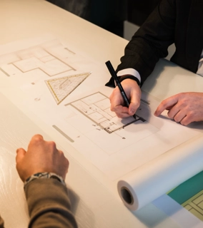 Architect schets een ontwerp en is in gesprek met klanten