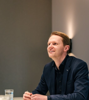 Vriendelijke architect zit aan tafel met klant