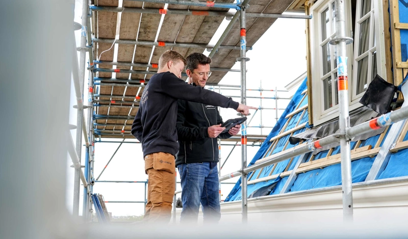 Uitvoerder en projectleider van Livingstone overleggen op de bouwplaats tijdens een verbouwing