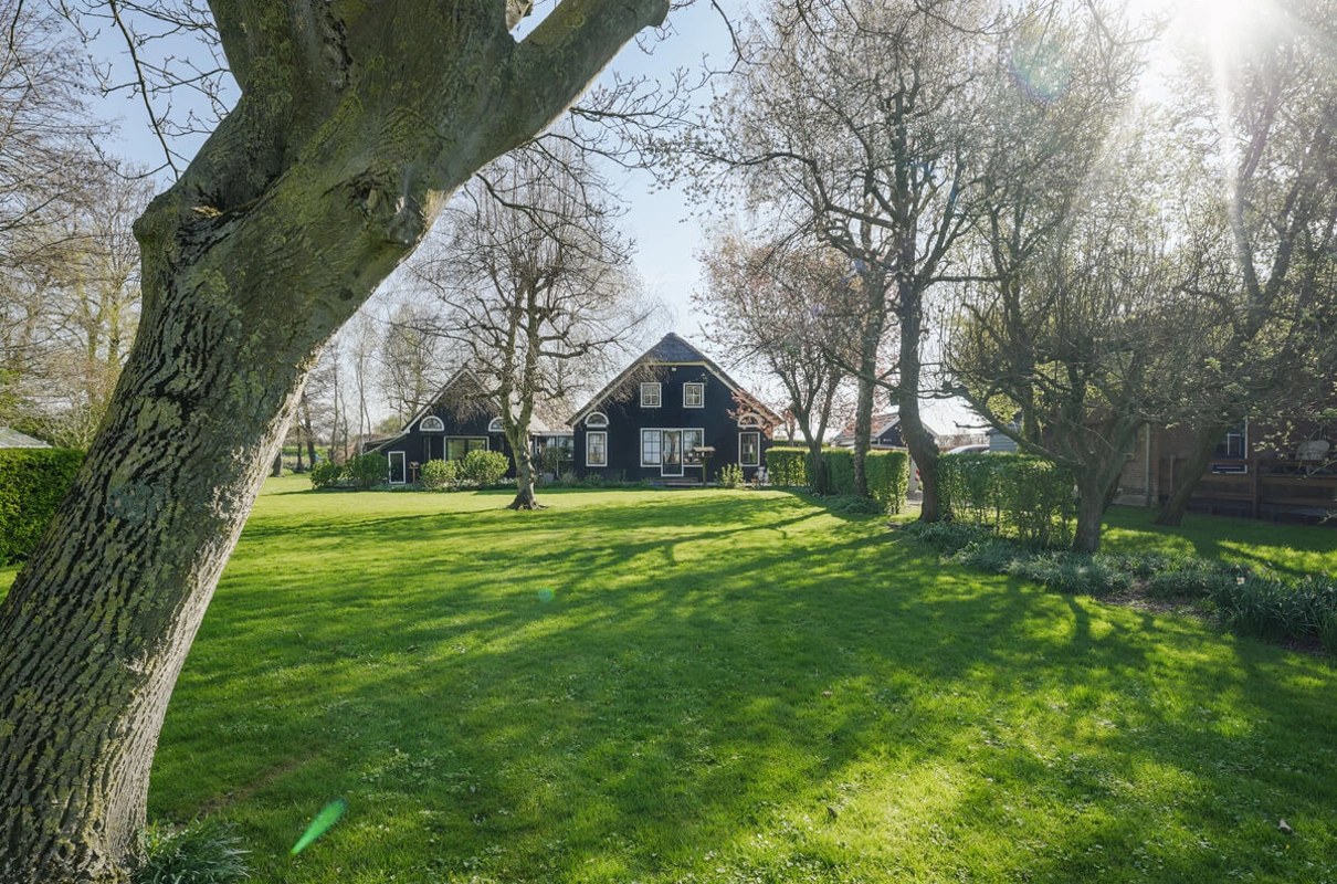 landelijke-boerderijwoning-vooraanzicht-donkere-gevel-gras.jpg