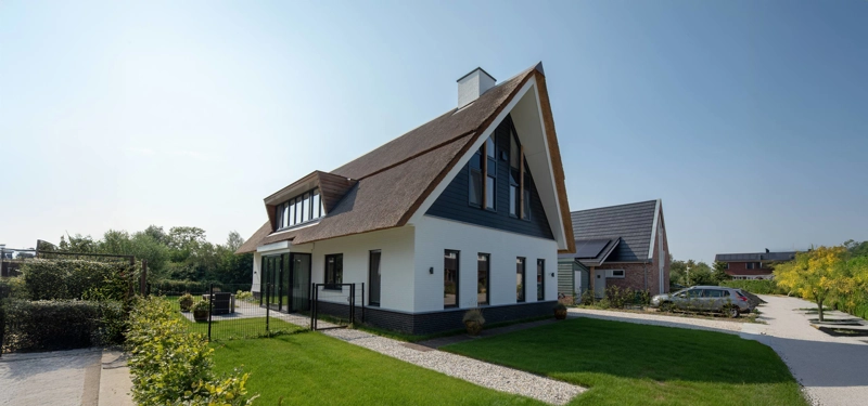 Boerderijwoning met wit zwarte gevel en rieten dak