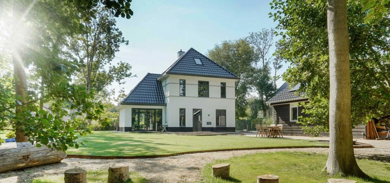 Voorzijde van herenhuis met witte gevel op groot perceel