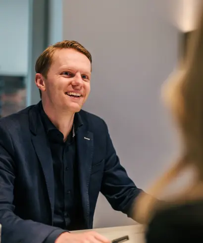 Vriendelijke architect zit aan tafel met klant