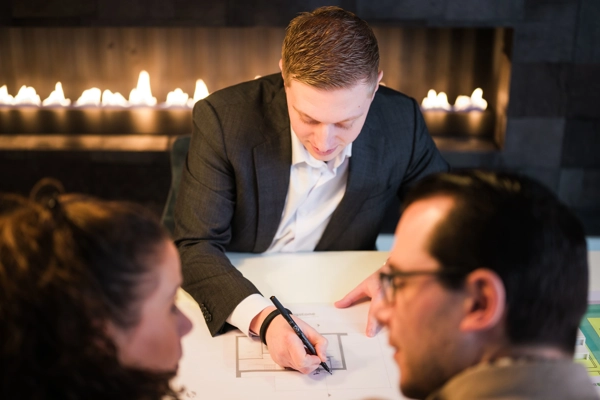 Architect schets een ontwerp en is in gesprek met klanten