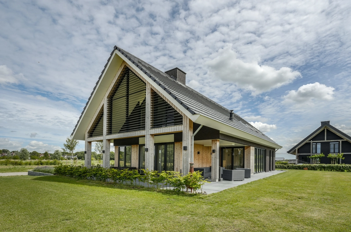 Schuin vooraanzicht van schuurwoning met houten spanten