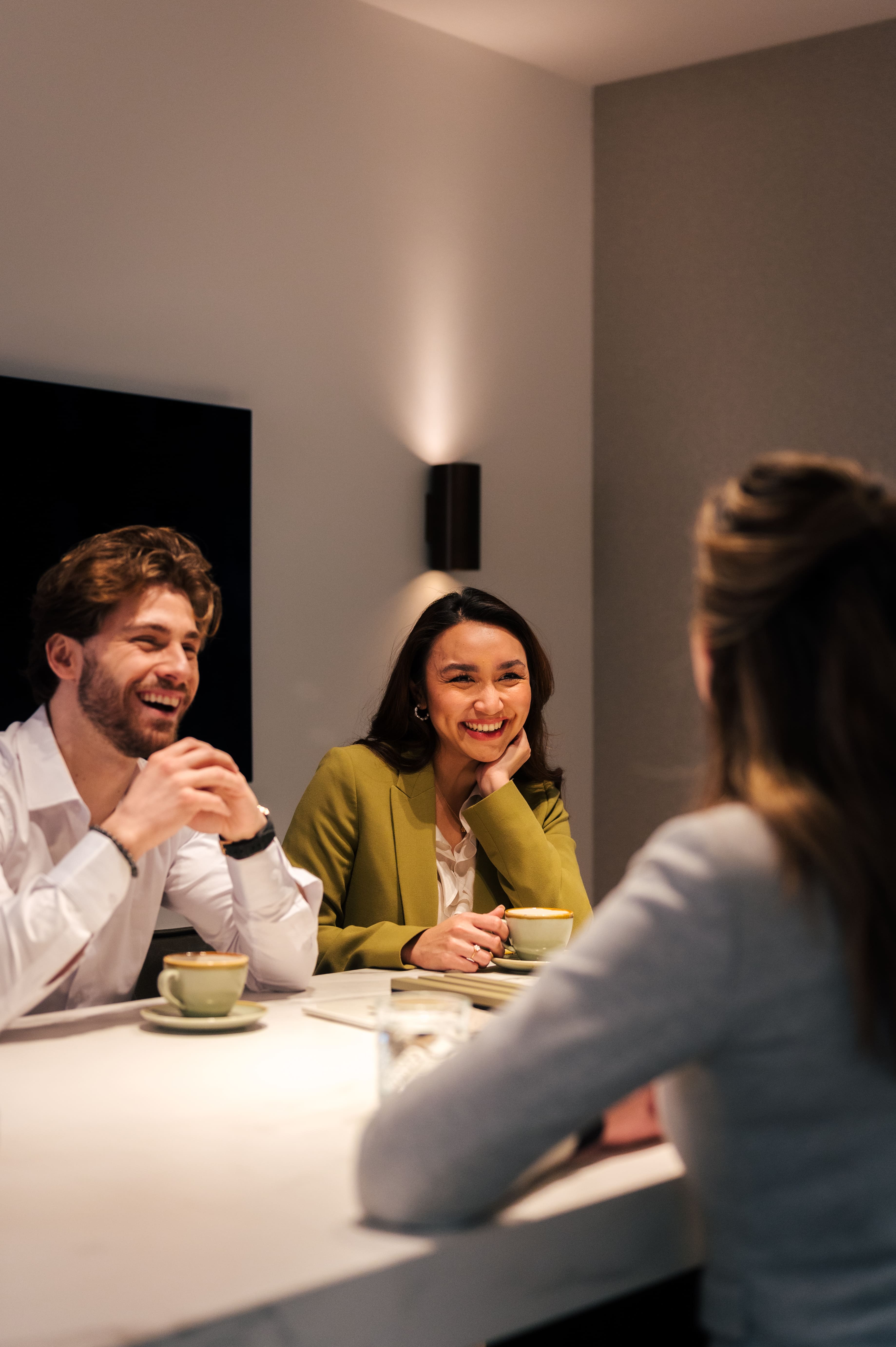 Een adviesgesprek tussen interieurontwerper en klanten aan tafel