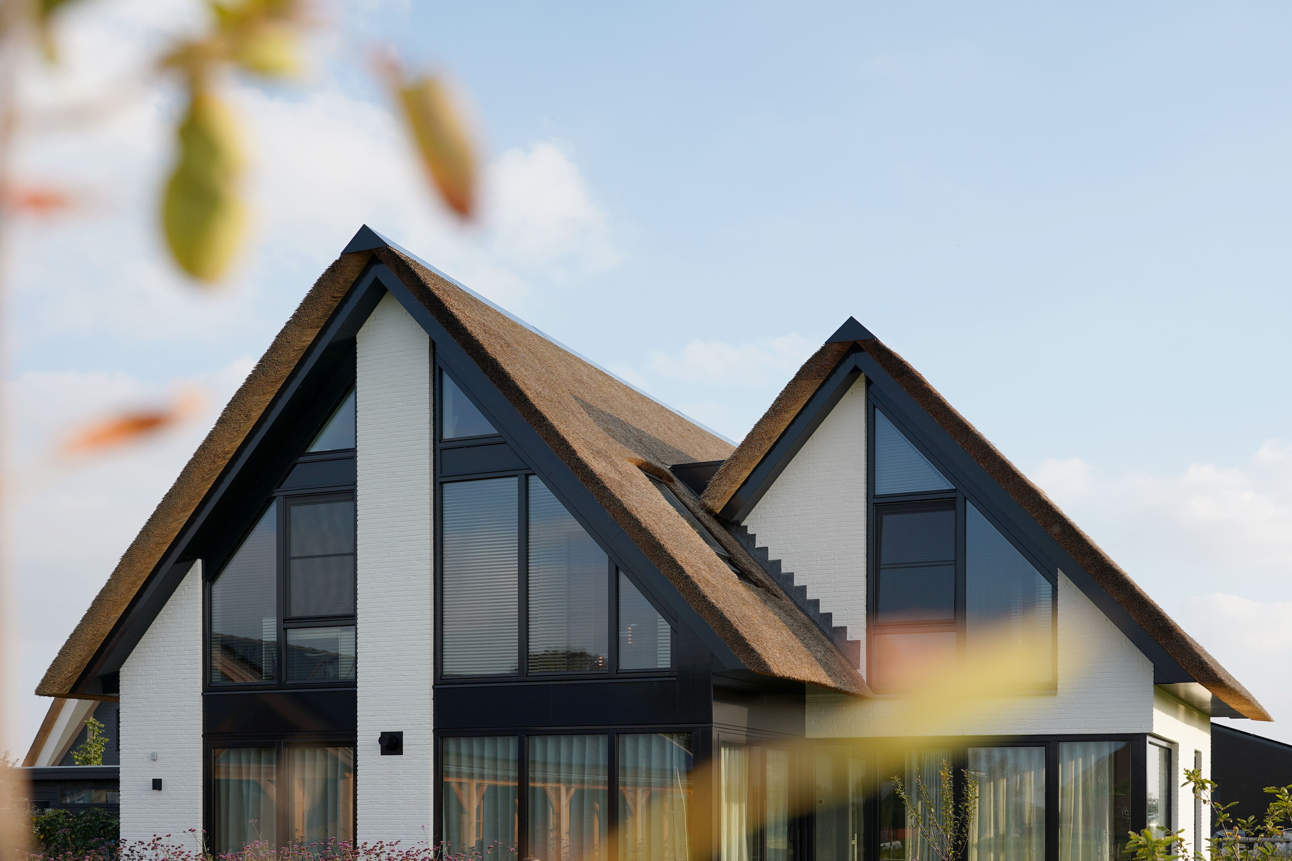 Vooraanzicht met rieten kap van moderne villa