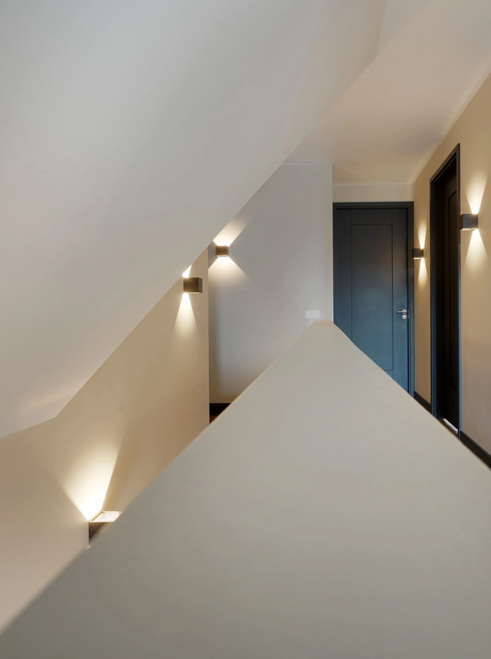 Een moderne, abstracte afbeelding van een overloop met wandverlichting en zwarte deuren