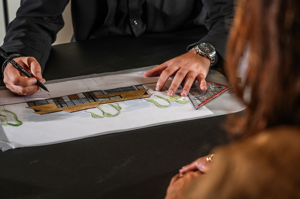 Architect schetst een ontwerp en is in gesprek met klanten 