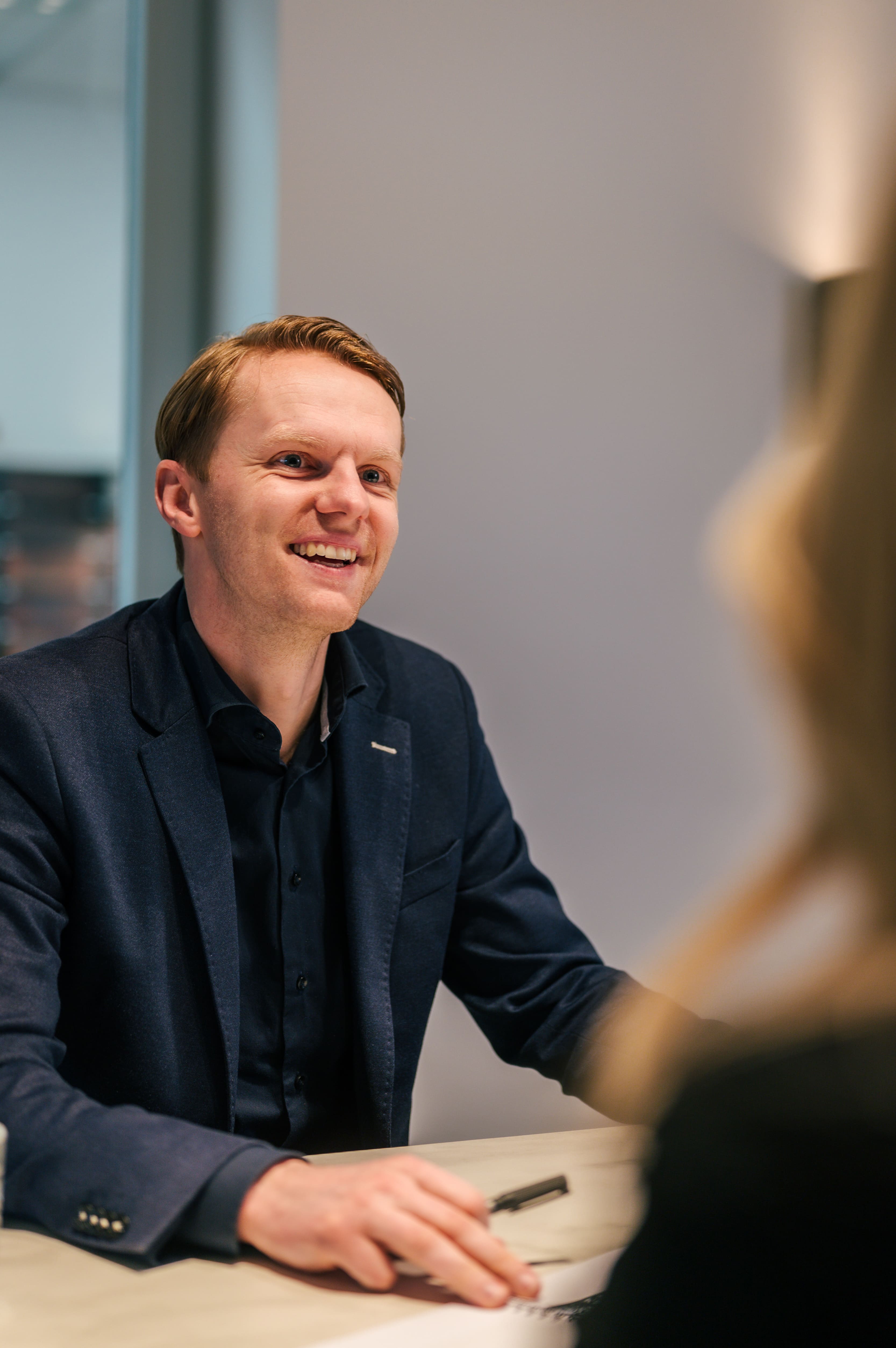 Vriendelijke architect zit aan tafel met klant