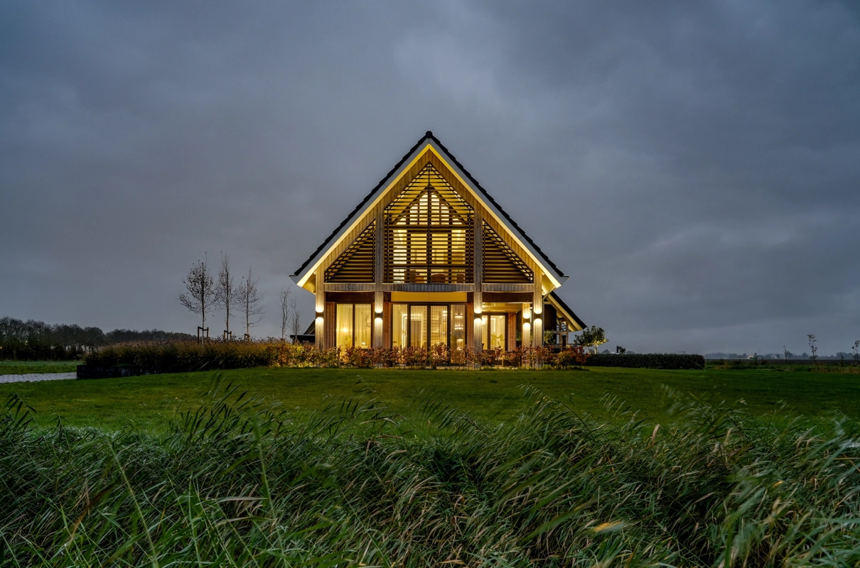 Avondfoto van schuurwoning met houten span lamellen