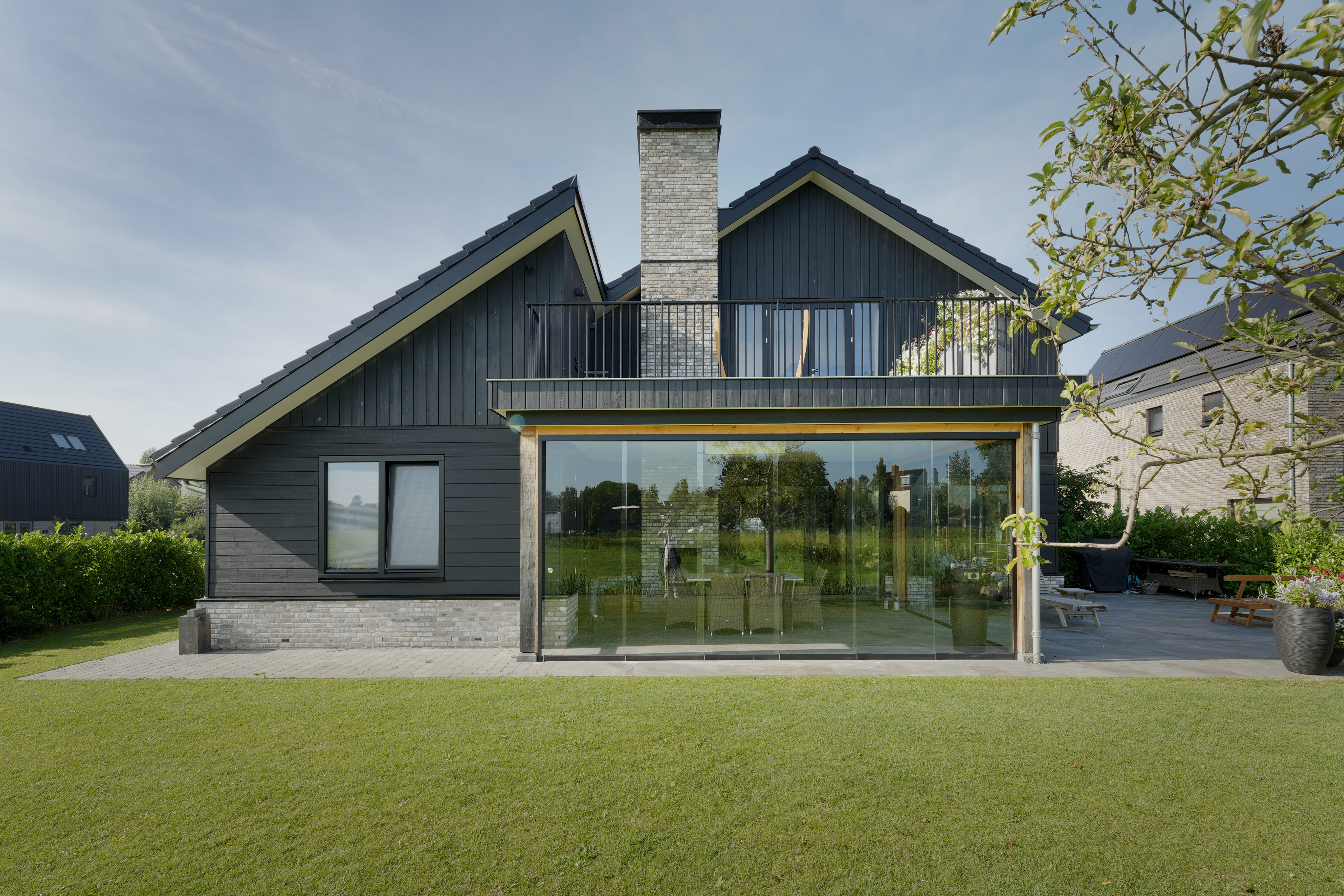 Achterkant van schuurwoning met serre