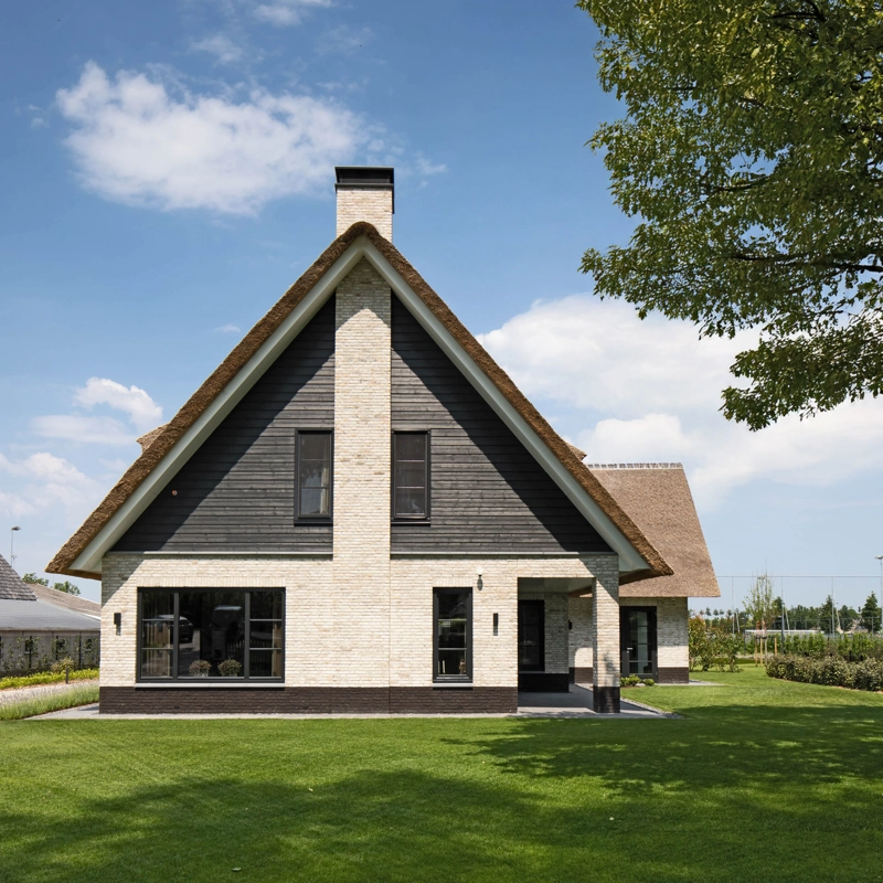 De voorgevel van een landelijke villa afgewerkt met metselwerk en hout
