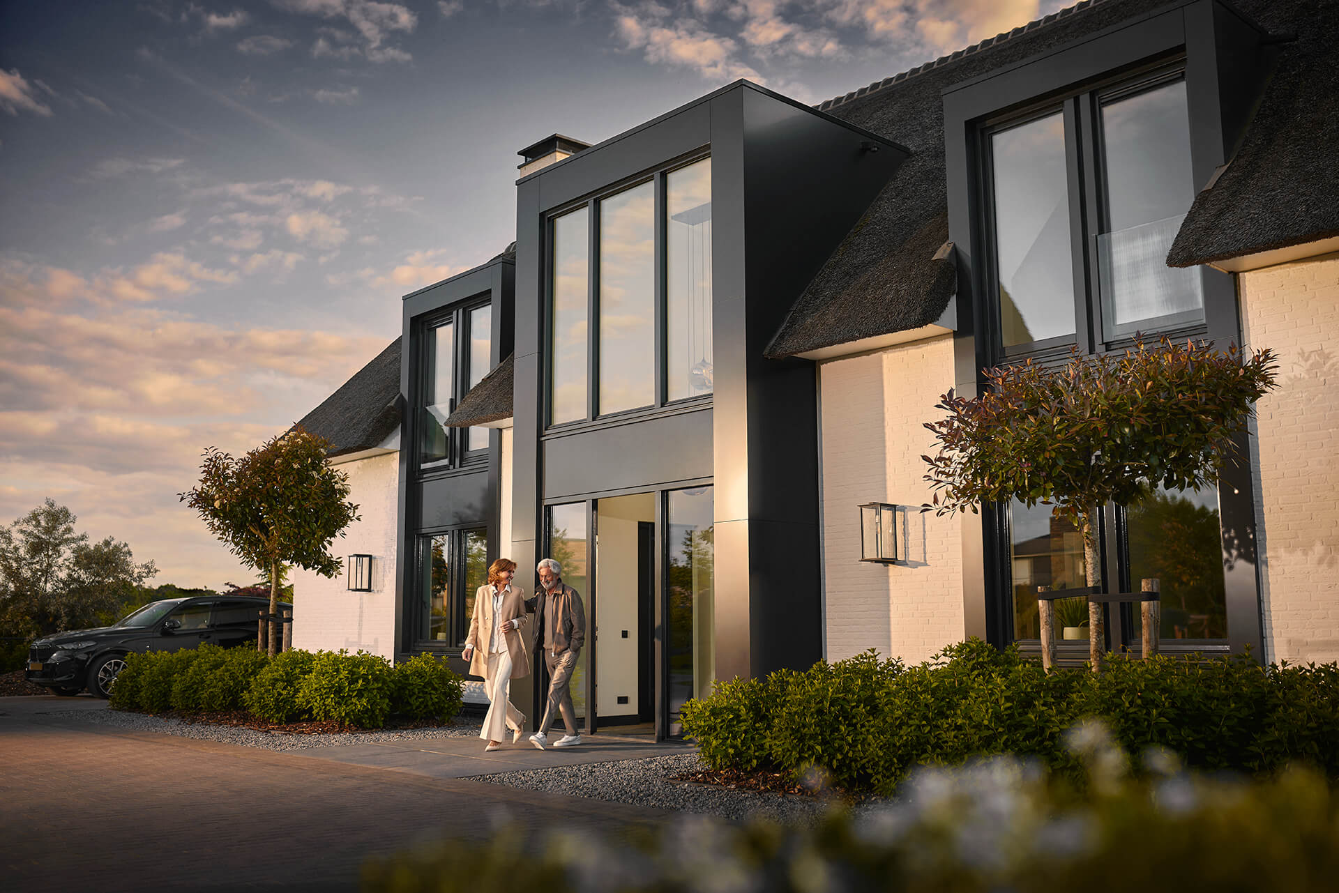 Echtpaar loopt voordeur uit van hun maatwerk villa