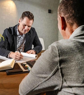 Vriendelijke architect zit aan tafel met klant