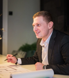 Vriendelijke architect zit aan tafel met klant